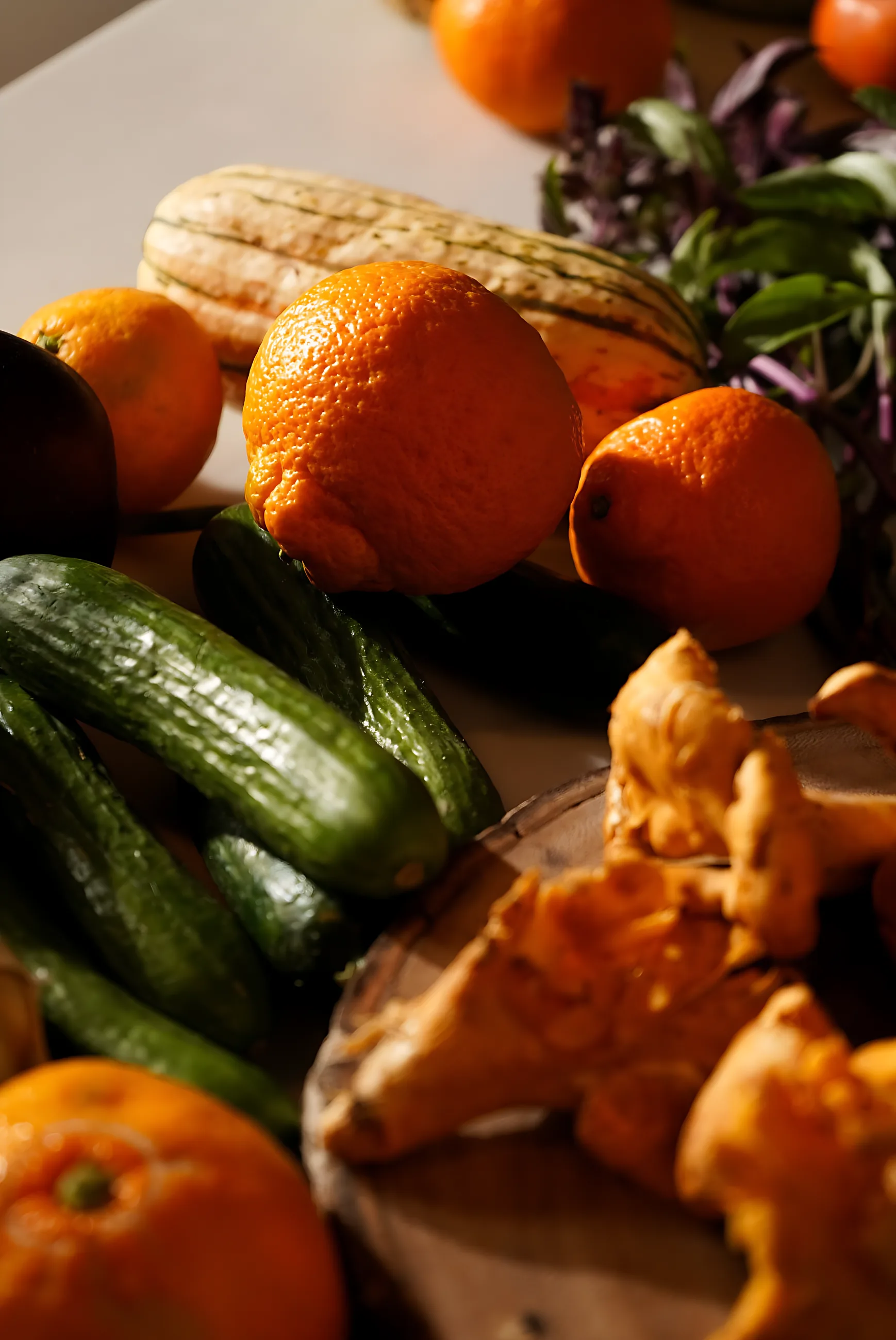 Chanterelles, tangerines, cucumbers and squash on the counter