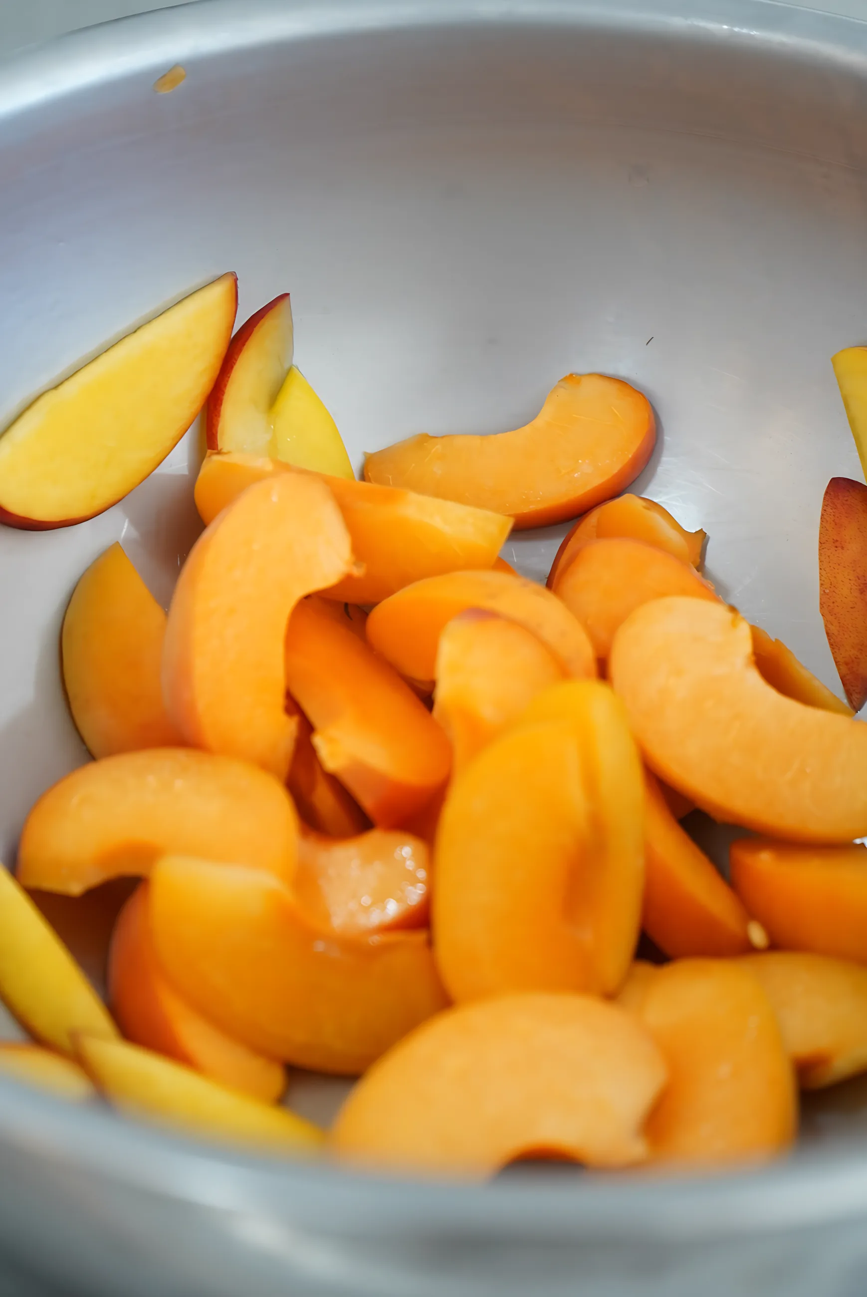 Fresh apricot halves in a steel bowl