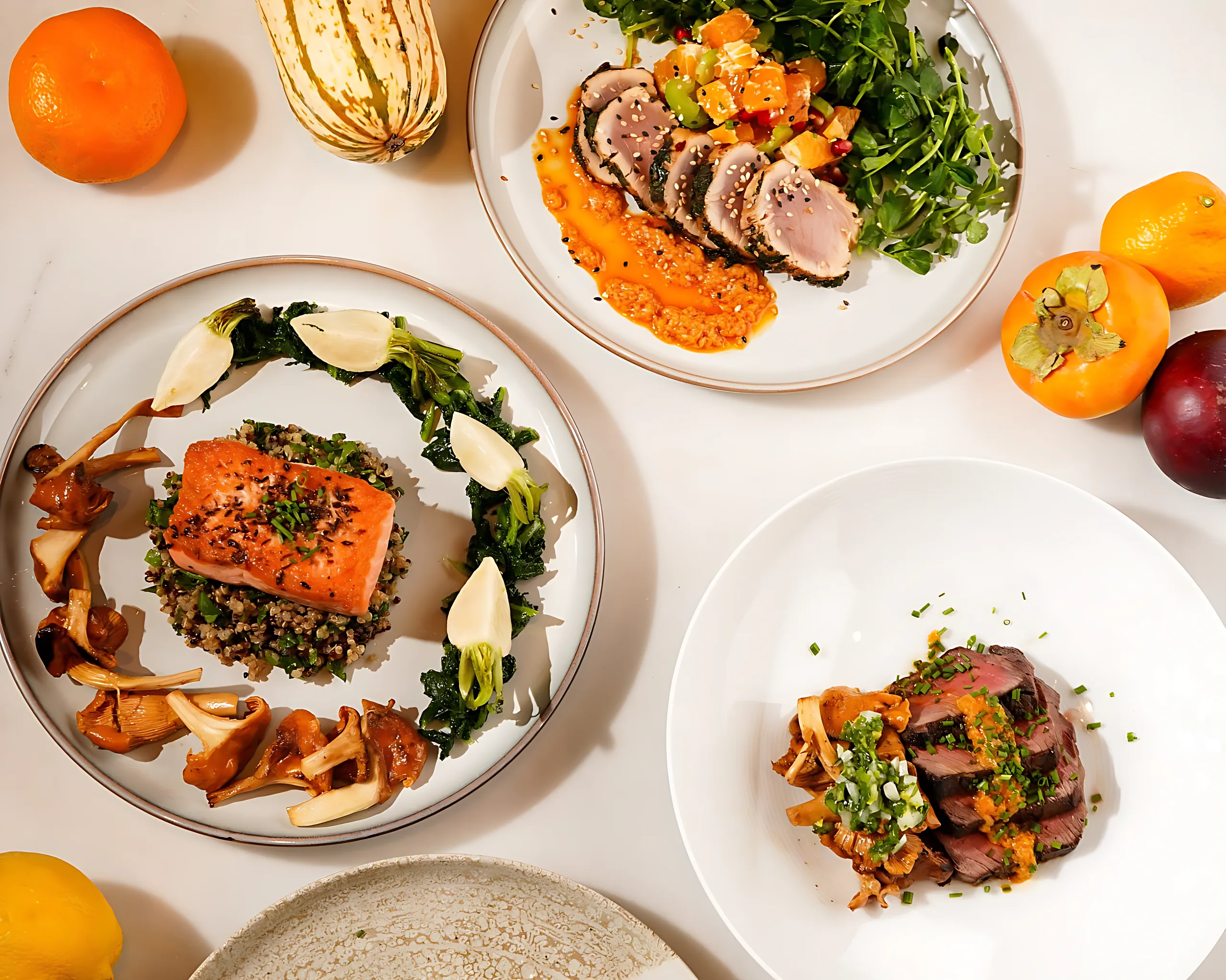 A table set with plates of salmon, duck and roasted vegetables
