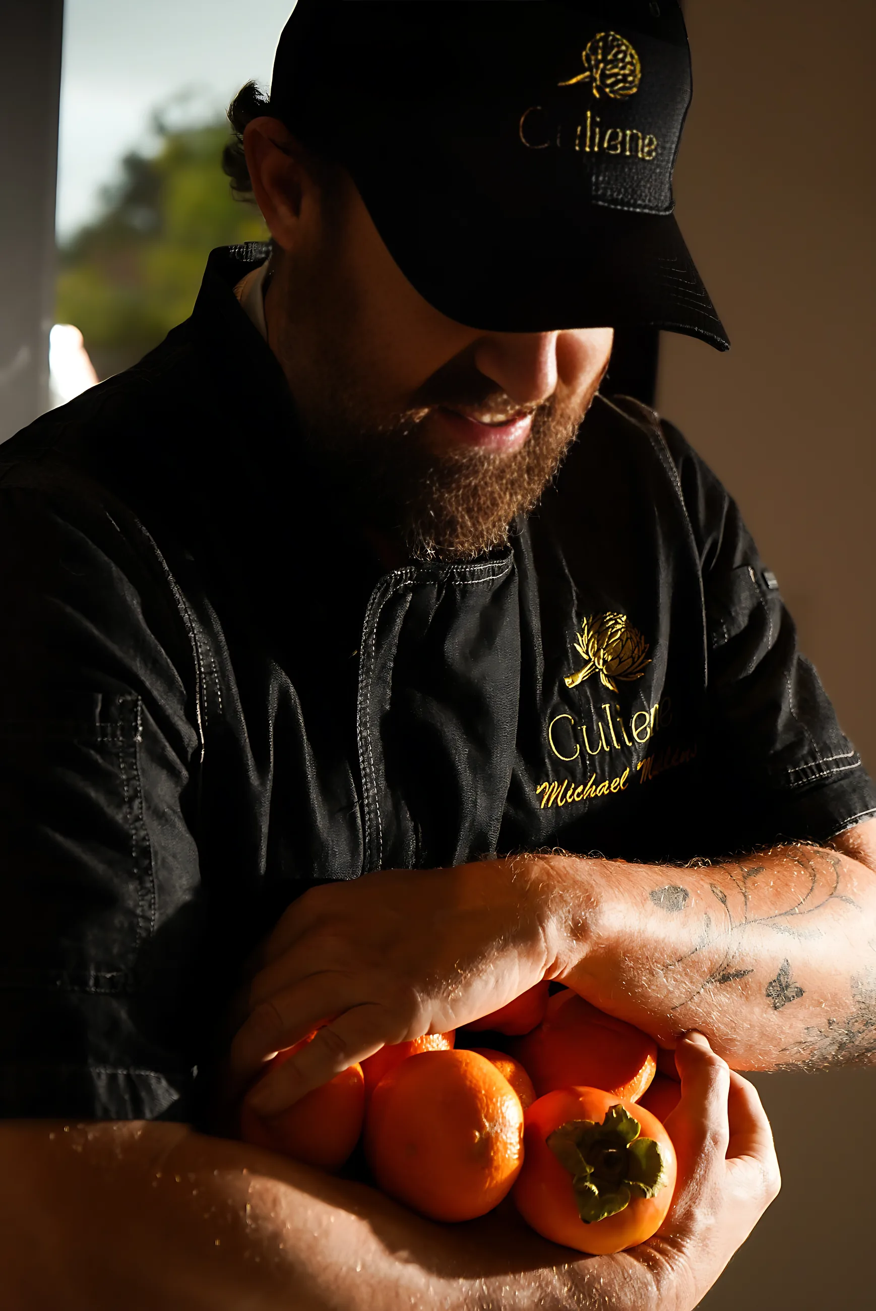 A Culiene chef holding an armful of oranges